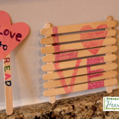 A book mark made of Popsicle sticks and a cut out heart and a Popsicle sign that says Love