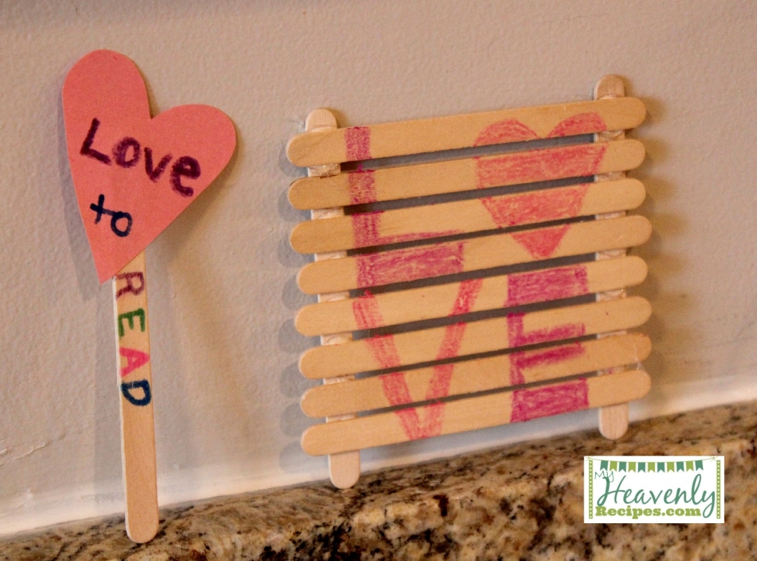 A book mark made of Popsicle sticks and a cut out heart and a Popsicle sign that says Love