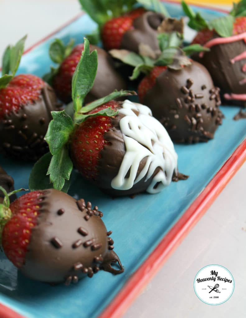 white and dark chocolate covered strawberries on a blue platter