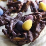 chocolate birds nest dessert with mini tiny candy eggs on yellow linen napkin