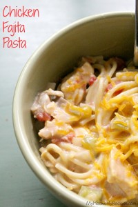 closeup of crock pot chicken fajitas pasta in a greenish white bowl next to red text