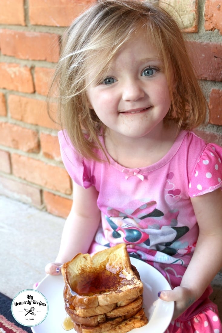 picture of child in pj's holding a plate of cinnamon french toast