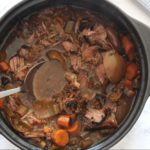 Crock-Pot Pot Roast in slow cooker with spoon and marble background