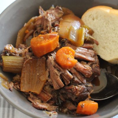 Crock-Pot Pot Roast in gray bowl and piece of bread