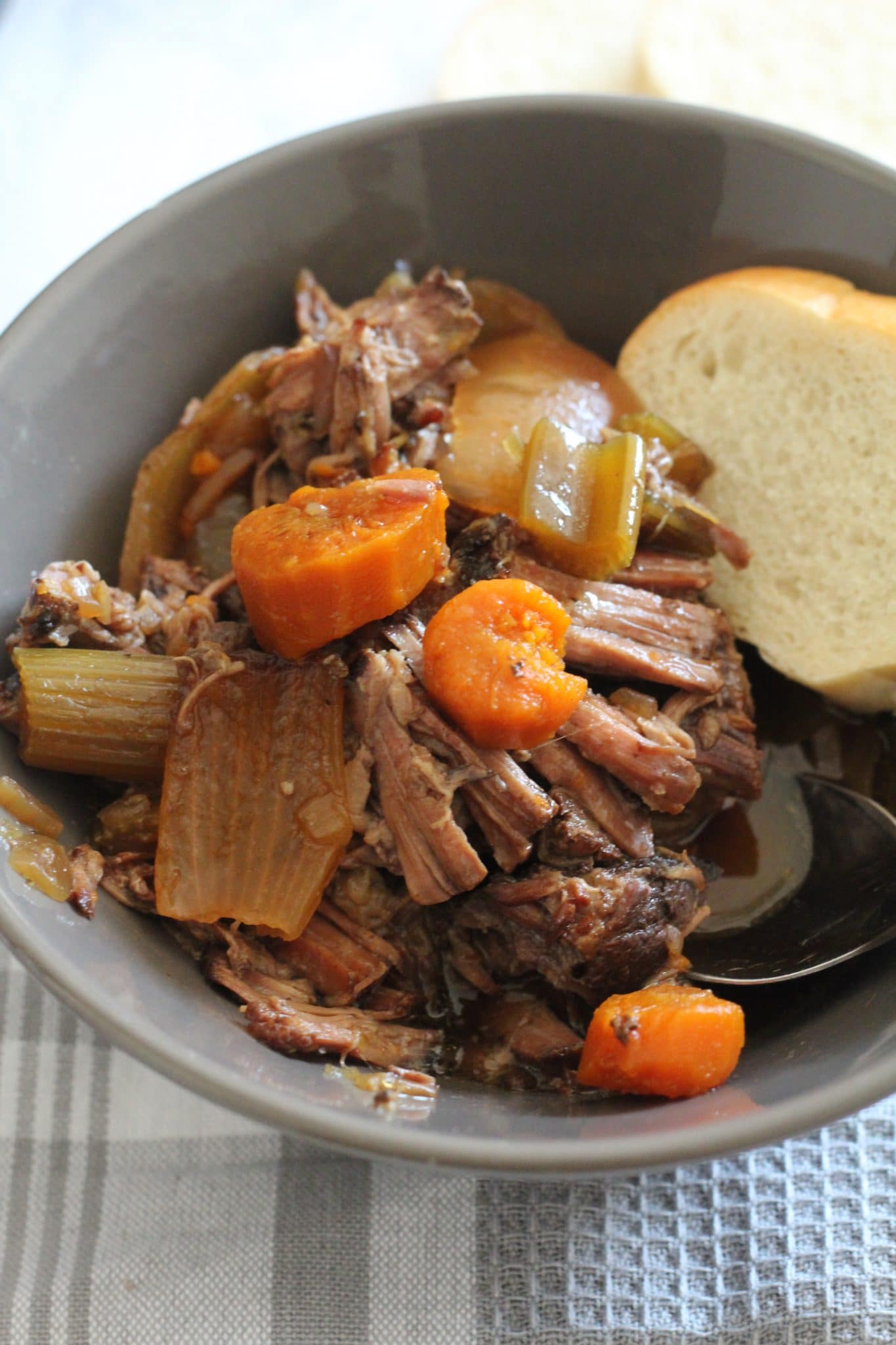 Crock-Pot Pot Roast in gray bowl and piece of bread