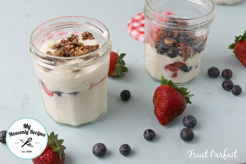 mason jars filled with yogurt fruit parfaits topped with granola