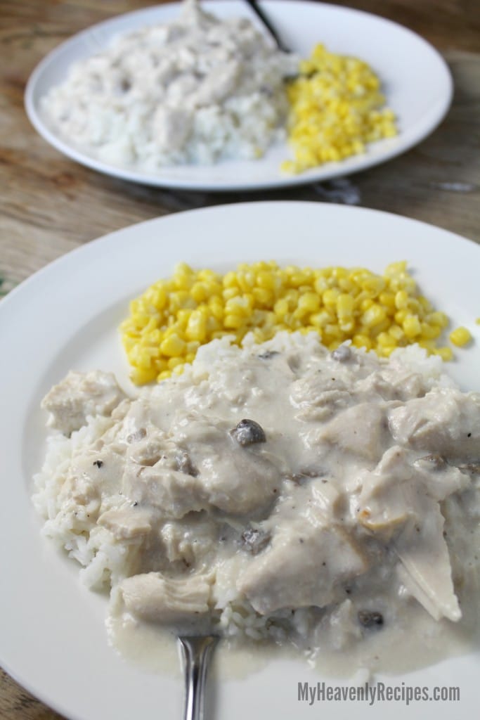 chicken over rice served on white plate with corn