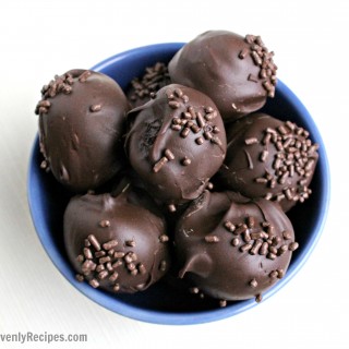 chocolate truffles with chocolate sprinkles in a blue bowl set on a white table