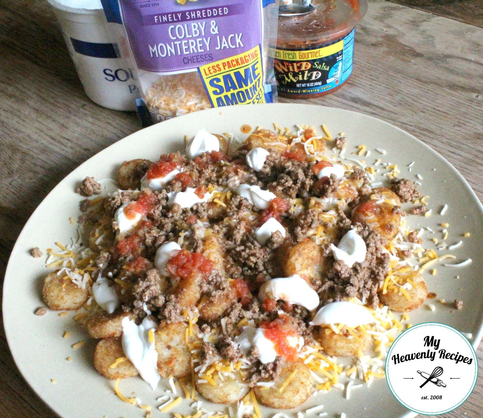 Tater Tot Nachos topped with meat, cheese, tomatoes, and sour cream