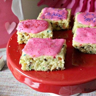 unicorn dessert cookie bars topped with pink frosting and colored sprinkles