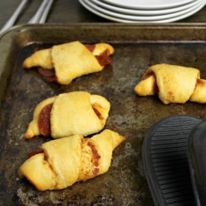 pepperoni stuffed crescent rolls on a baking sheet