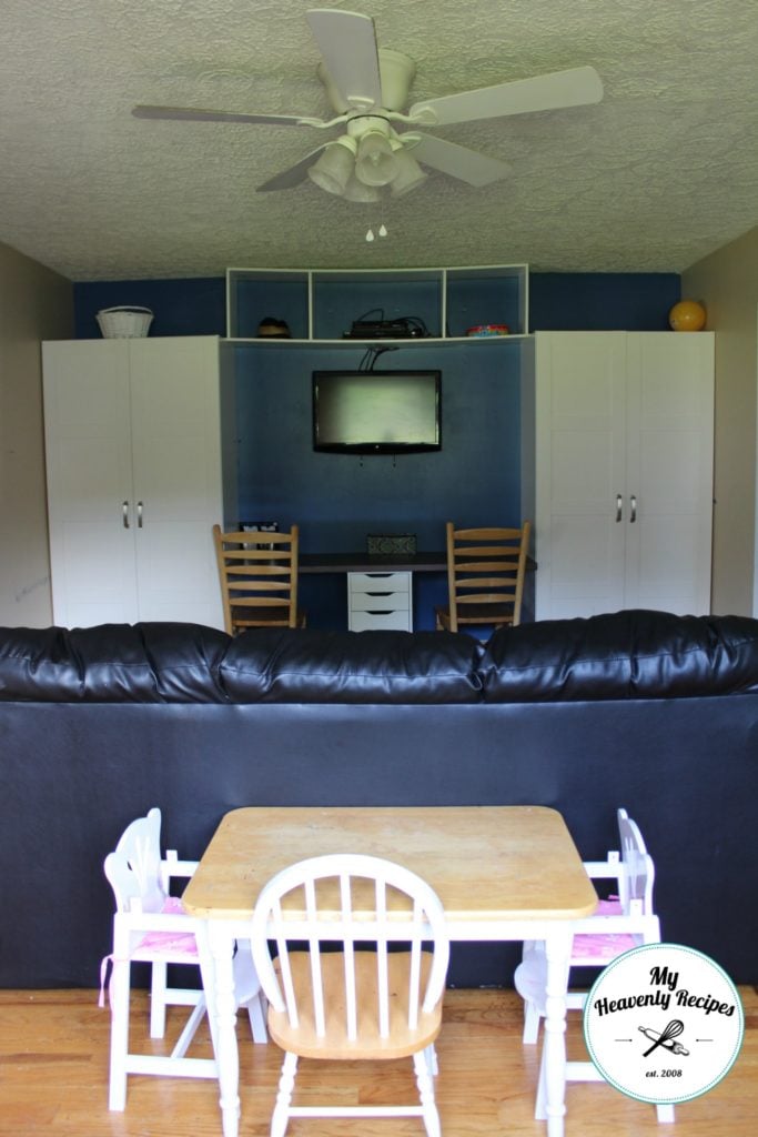 ikea wardrobe on blue painted wall with a desk in the middle