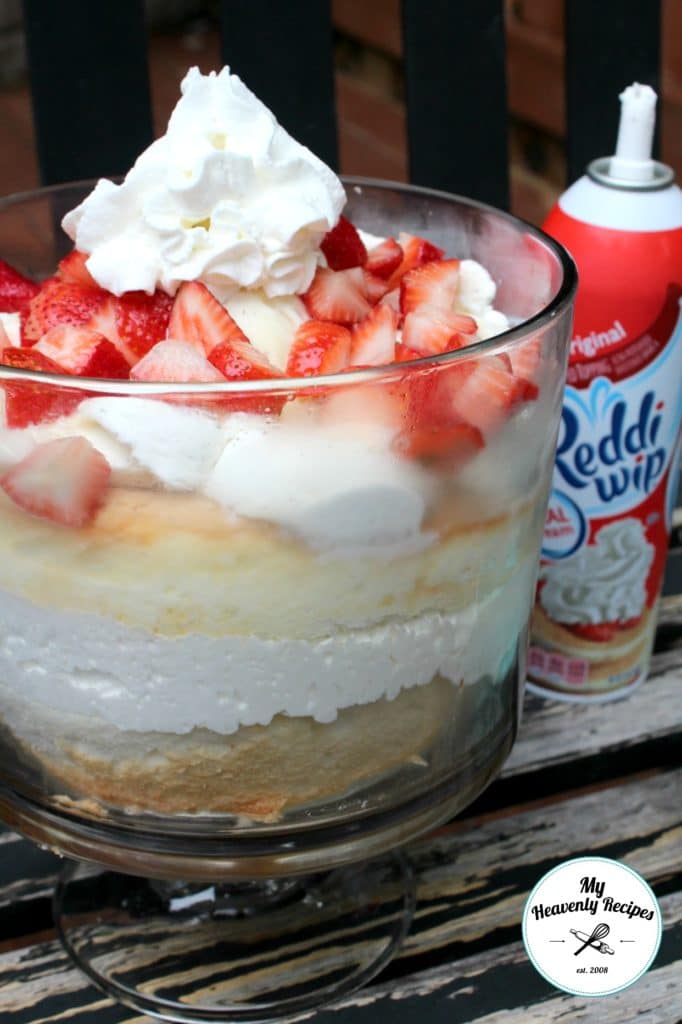 strawberry angel food cake recipe in a trifle bowl with a can of reddi whip in the background