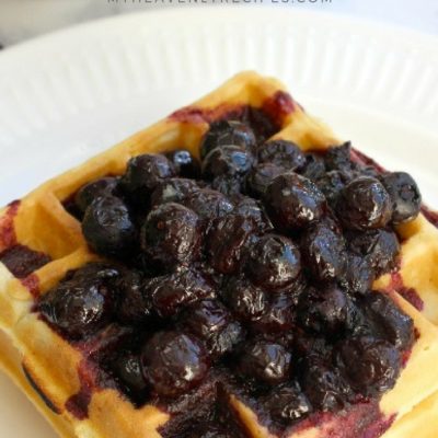 Waffles on white plate topped with blueberry compote