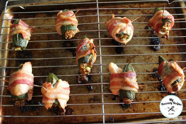 bacon wrapped stuffed jalapeno poppers on a grilling rack