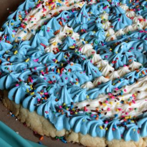 sugar cookie cake decorated with blue and white whipped buttercream frosting