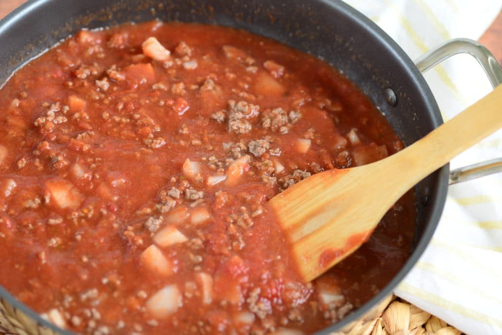 chili sauce in skillet with tomato sauce, tomatoes, hamburger, onions and spices