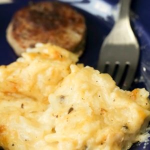 cheesy Hash Brown Casserole plated on blue plate with sausage