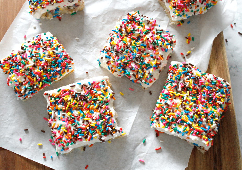 funfetti sugar cookie bars with white whipped icing and funfetti sprinkles overhead shot