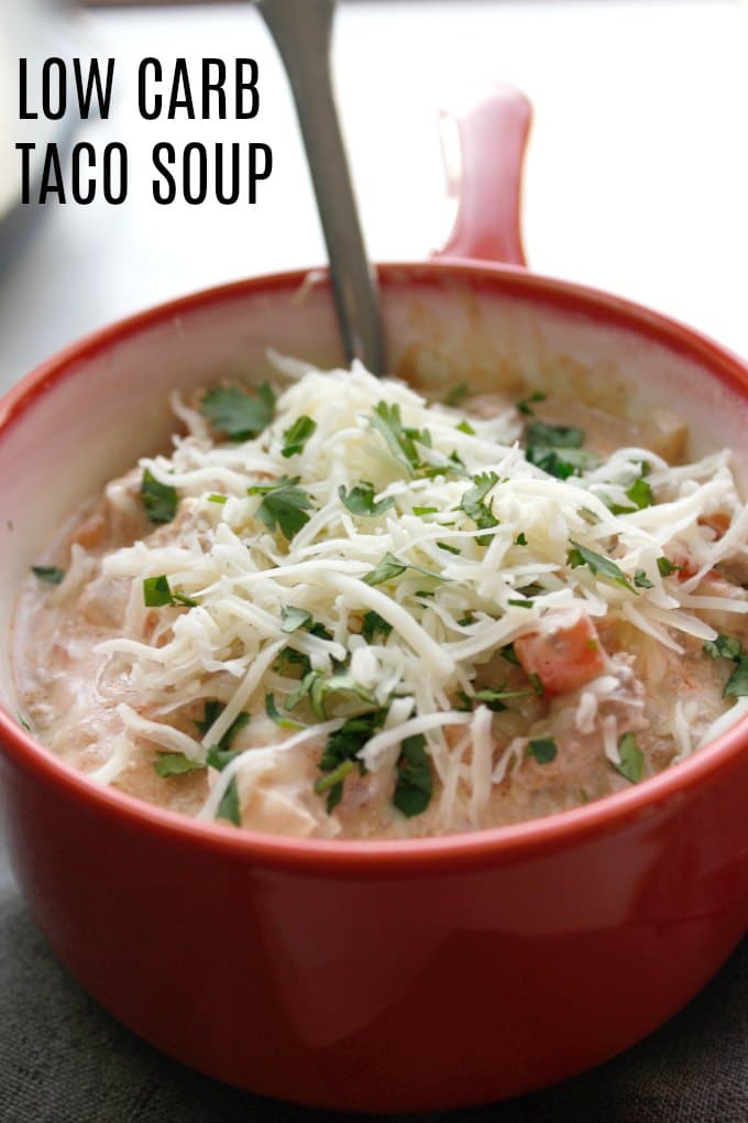 low carb taco soup in a red bowl with cheese on top