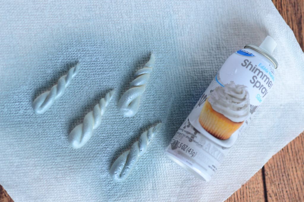 overhead shot of white fondant shaped into unicorn corns with edible glitter spray
