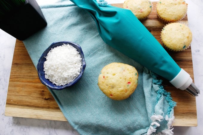 overhead view of easter cupcakes on green towel next to pastry bag