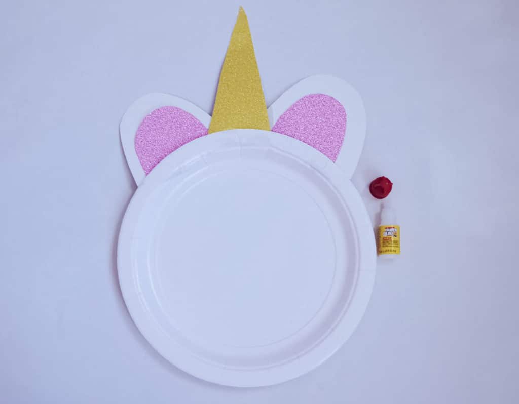 unicorn craft plate without face with horns and ears next to glue