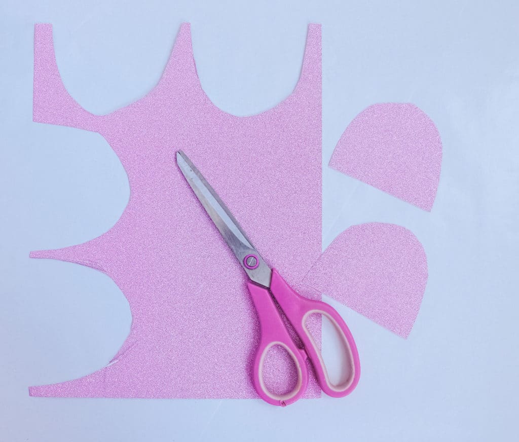 cut out pieces of pink felt to be used in unicorn craft plate next to scissors