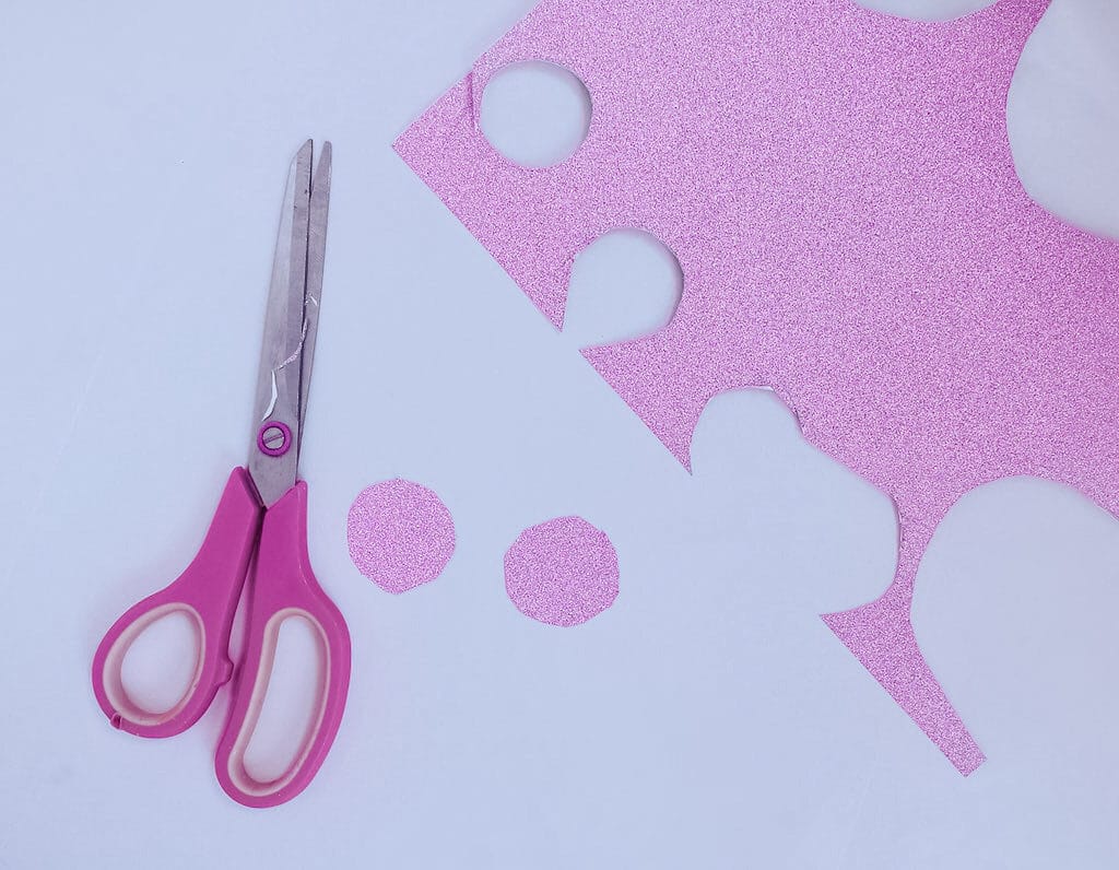 pink scissors next to pink paper to be used in unicorn craft plate