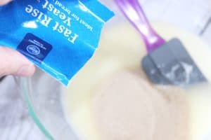 pouring fast rise yeast into bowl for pull apart roll recipe