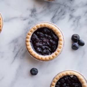 mini blueberry pies on a marble surface