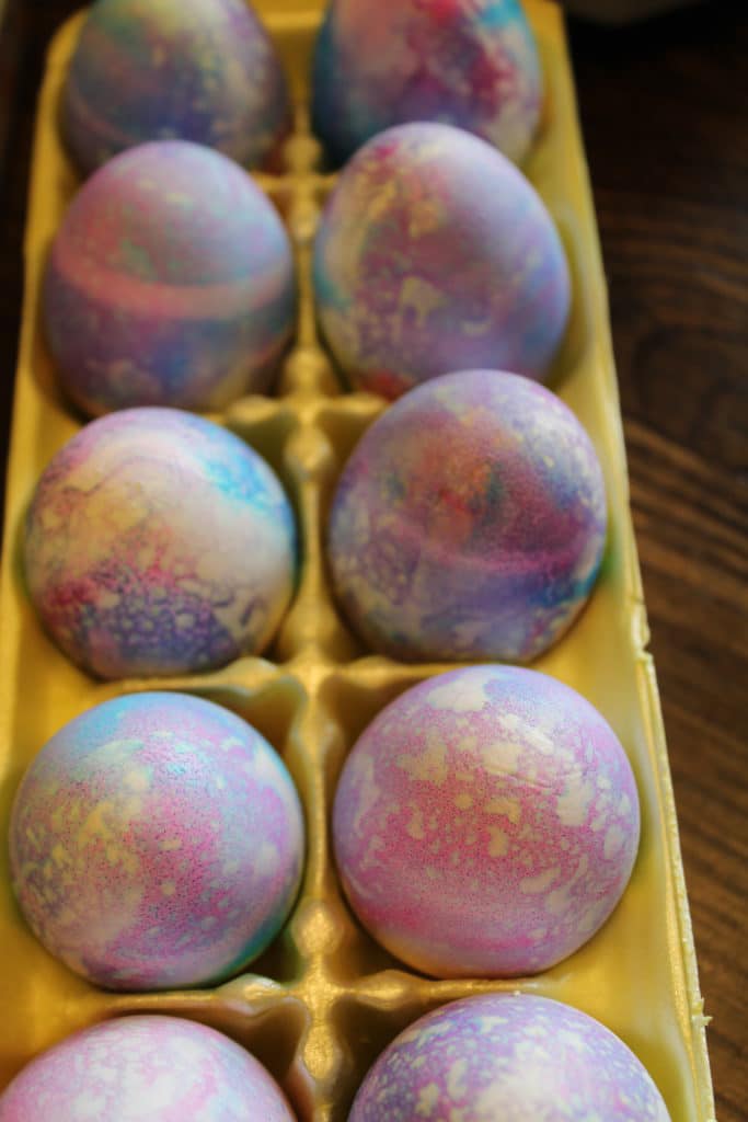 close up of shaving cream dyed eggs in egg carton