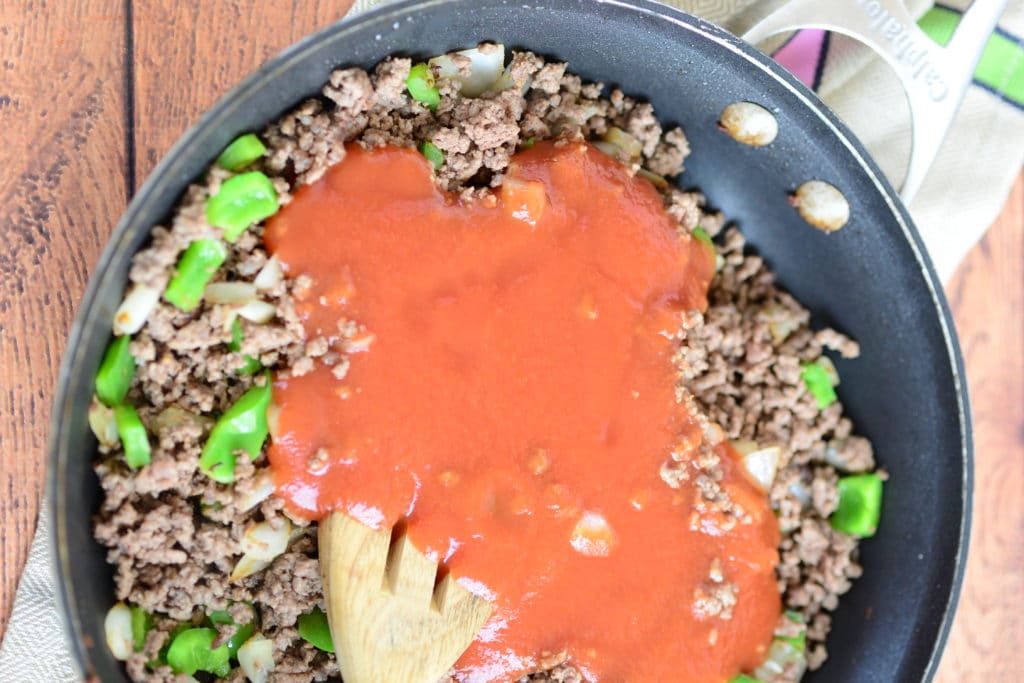 overhead shot of hamburger, green pepper, onion and tomato sauce in skillet