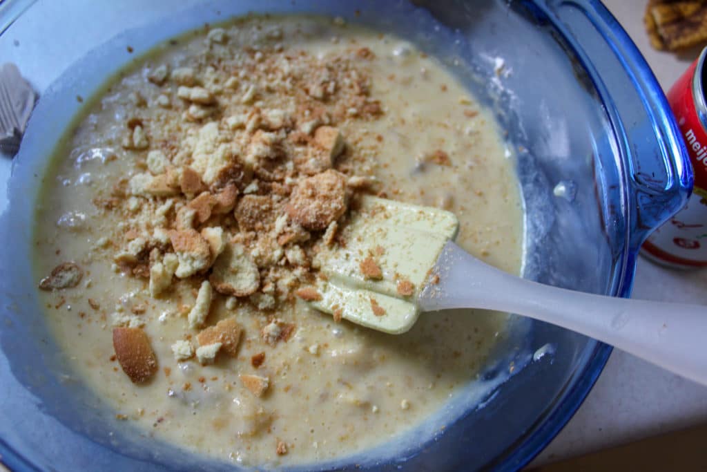 crushed wafers in mixing bowl with evaporated milk, mashed bananas and whipped cream