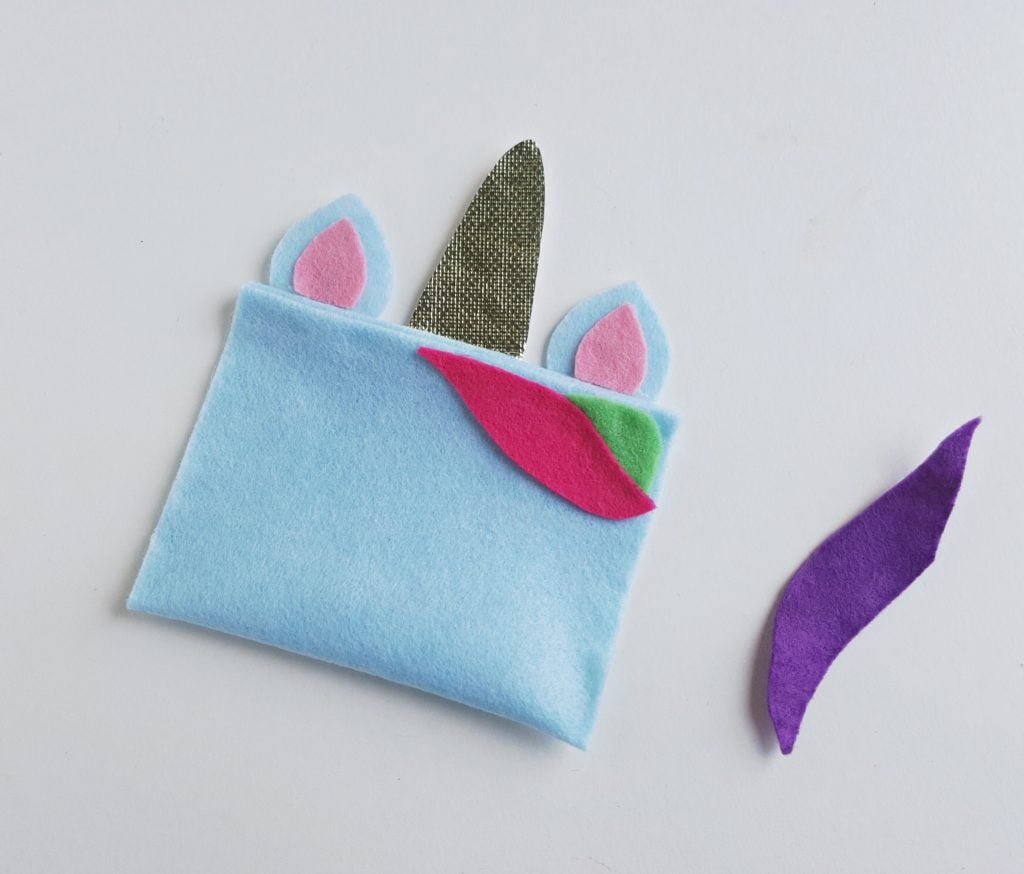 unicorn pencil case pieces next to purple fabric