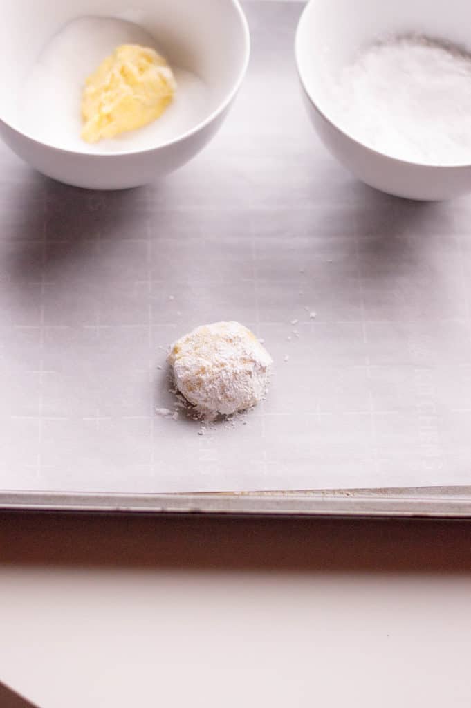 lemon crinkle cookie on parchment paper with icing sugar