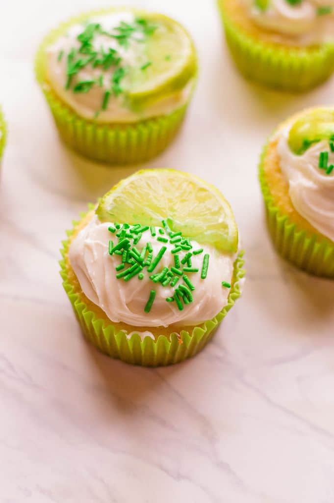 closeup of margarita cupcakes with lime slice on top plus green sprinkles