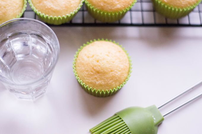 closeup of margarita cupcakes with tequila in a clear glass next to it