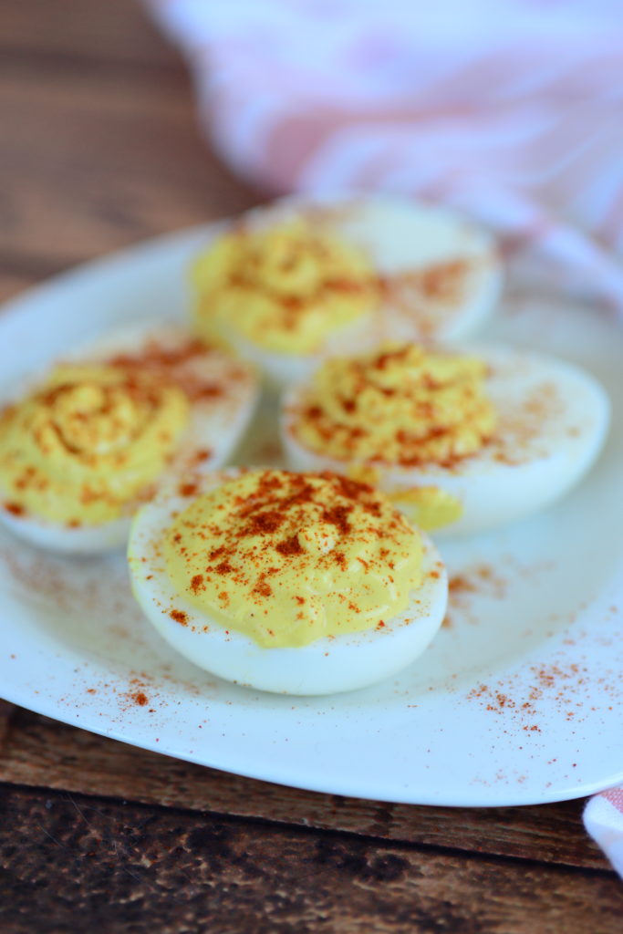 a close up shot of the best deviled eggs on a plate sprinkled with paprika