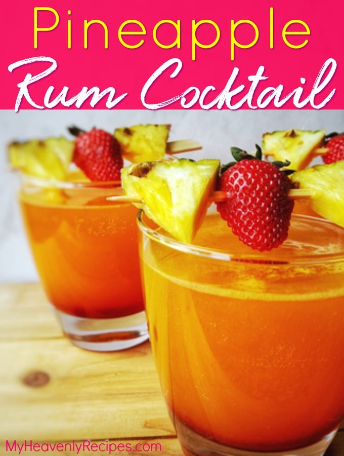 two pineapple rum cocktail glasses with pineapple and strawberries attached to a skewer on top