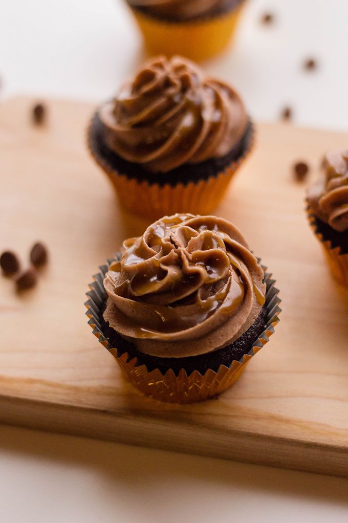 closeup view of caramel cupcakes in a line on a wooden tray