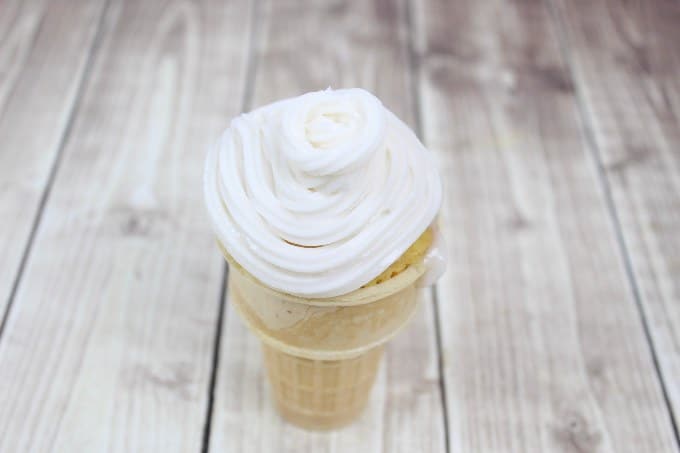 overhead view of ice cream cone cupcake with vanilla icing on top