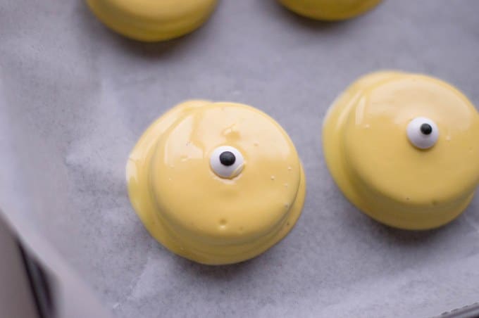 candy eyes on yellow covered oreos to be used for minion oreos