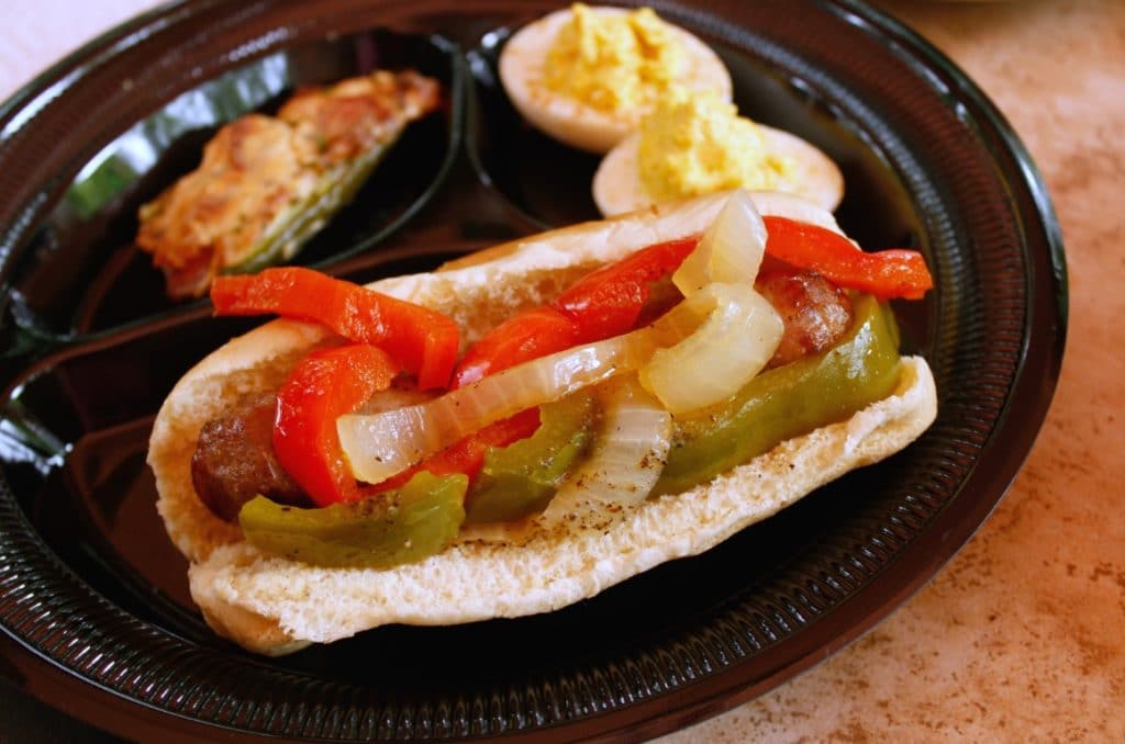 yuengling brats with beer smothered peppers on black plate