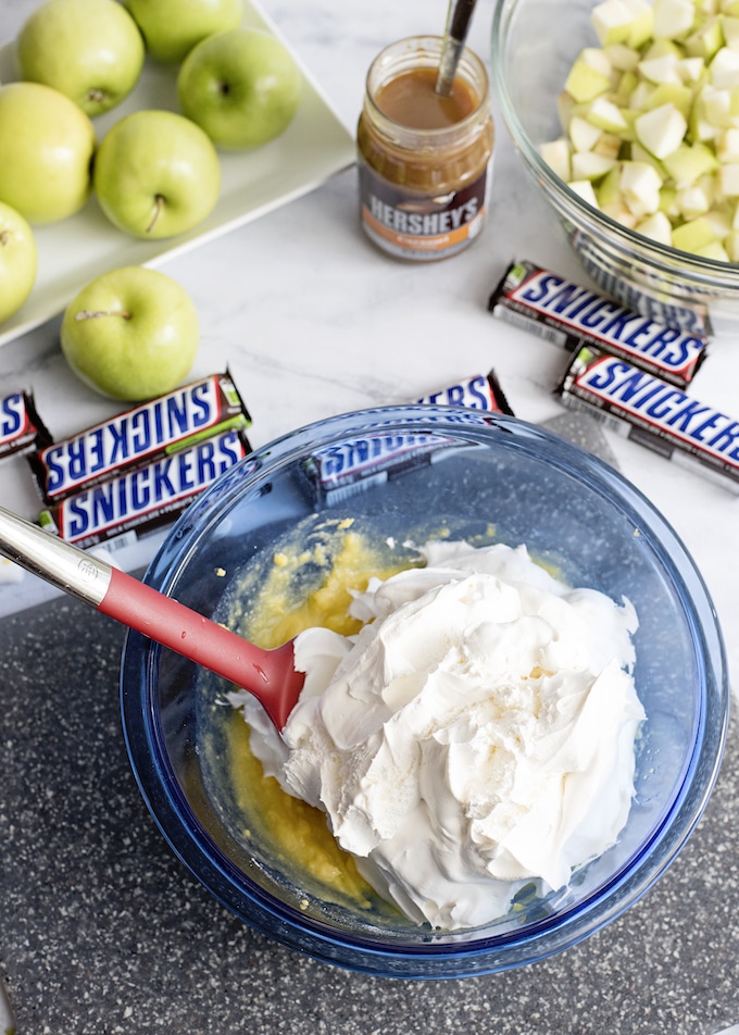 Combine Caramel Apple Snickers Salad ingredients in a mixing bowl.