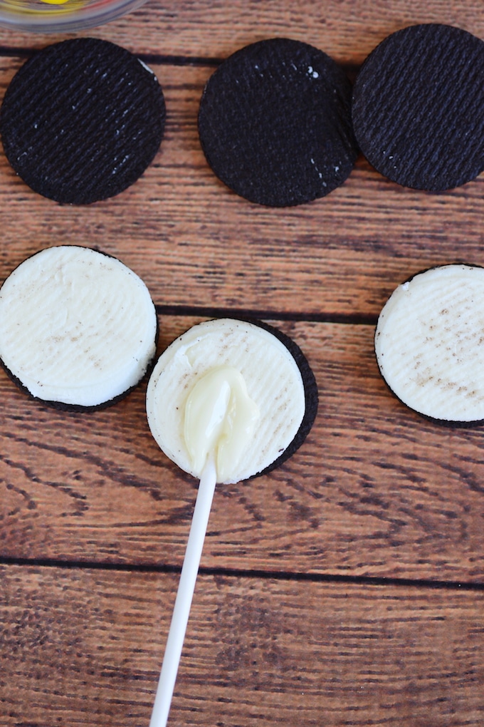 Dip one end of the lollipop sticks in white chocolate and center it on the Oreo half with cream. Place the other half over it to secure the stick.