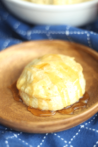homemade biscuit on wooden plate drizzled with honey