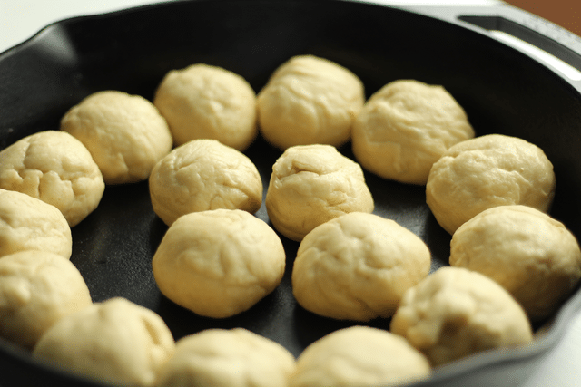 balls of dough formed in cast iron skillet