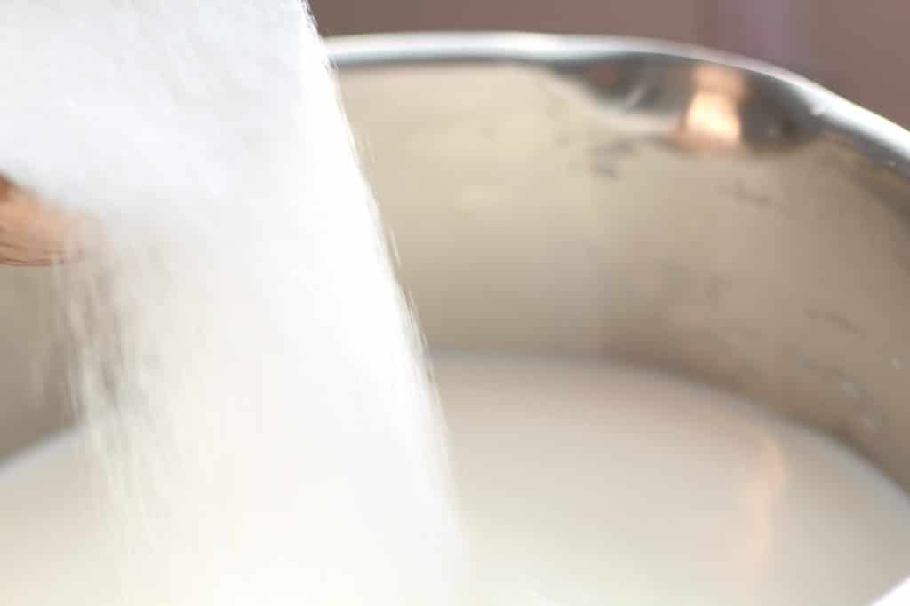 upclose shot pouring sugar in pan
