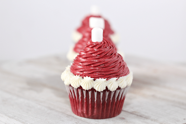 red velvet cupcakes with white icing, red icing and mini marshmallow